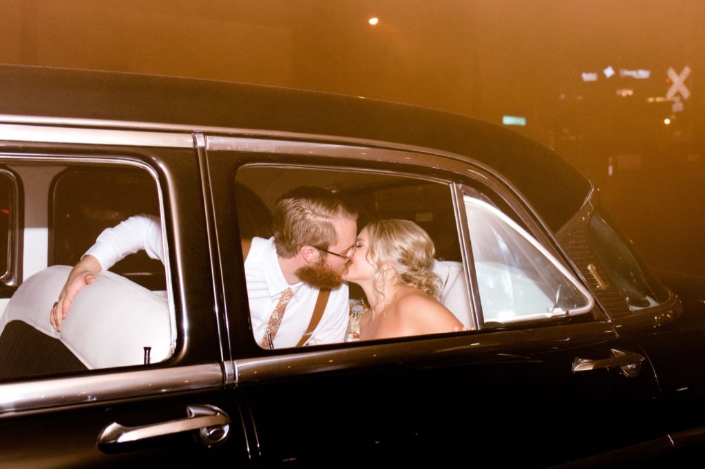 couple kisses in getaway car
